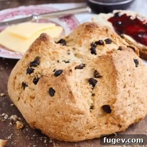 A loaf of traditional Irish soda bread, with a pat of butter in the background.
