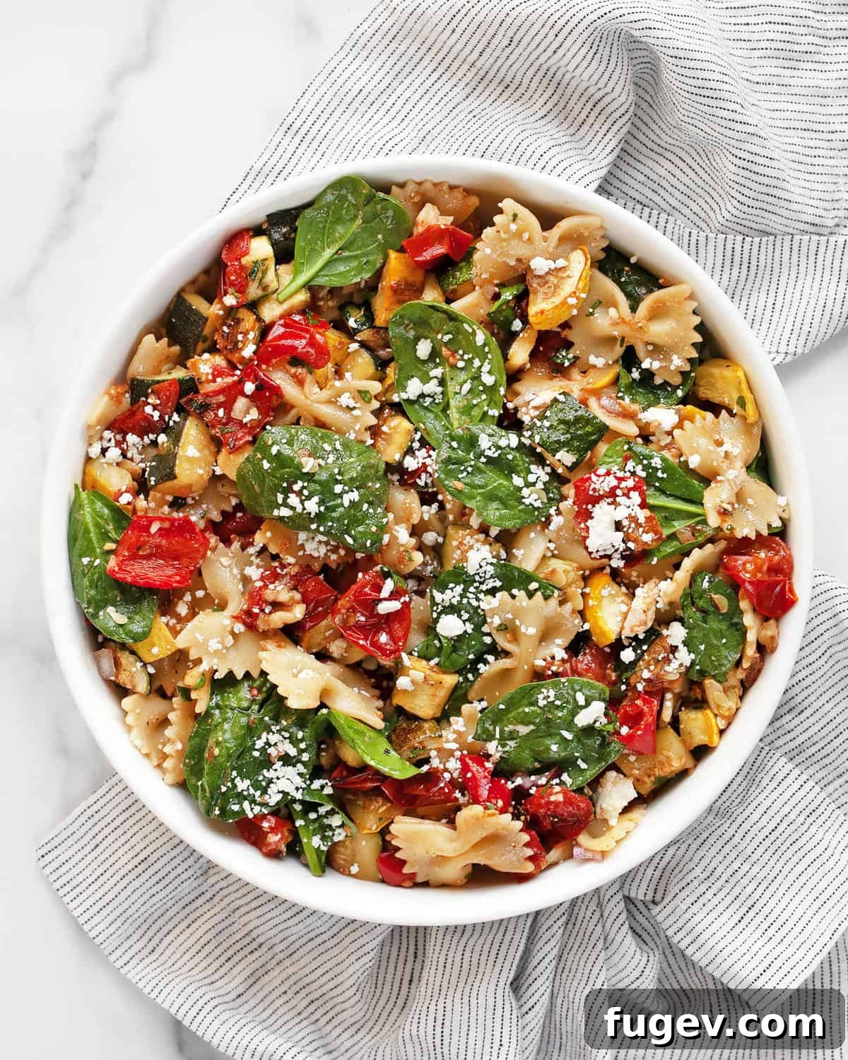 Golden Roasted Veggie Farfalle Salad 2 A vibrant bowl of roasted vegetable bow tie pasta salad, showcasing colorful vegetables and farfalle pasta.