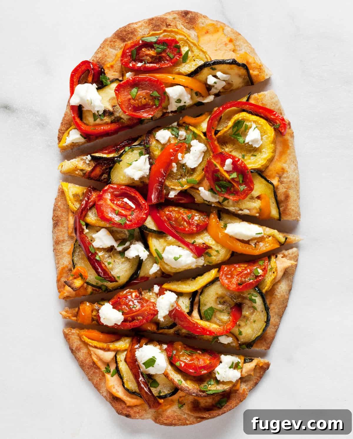 Roasted Garden Vegetable Naan Flatbread 2 Deliciously sliced naan flatbread pizza topped with a colorful medley of roasted vegetables and crumbled feta cheese.