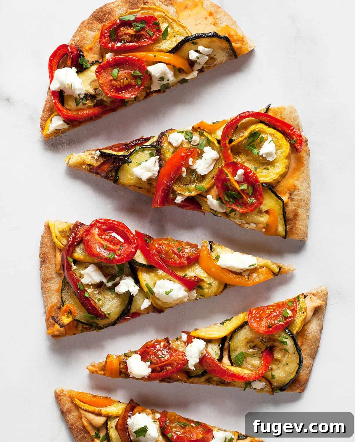 Roasted Garden Vegetable Naan Flatbread 8 Perfectly sliced roasted vegetable naan flatbread pizza, beautifully topped with colorful vegetables and crumbled feta, ready to be served.