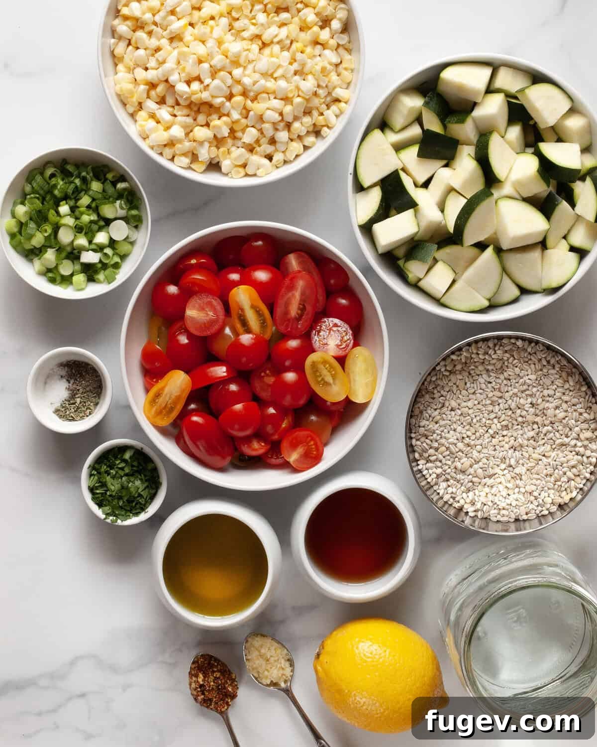 Golden Roasted Vegetable Barley Salad 3 A flat lay of fresh ingredients including pearl barley, cherry tomatoes, corn on the cob, zucchini, olive oil, red wine vinegar, lemon, garlic, oregano, parsley, whole grain mustard, salt and pepper.