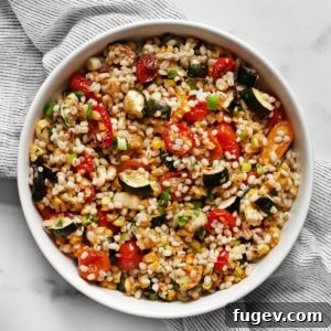 Tomato, corn & zucchini barley salad in a bowl.