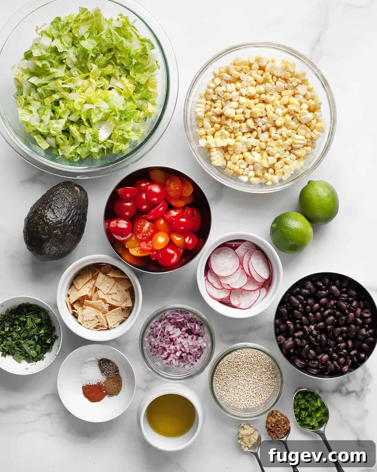 Quinoa Fiesta Bowl 3 A vibrant display of fresh ingredients for Quinoa Taco Salad including roasted corn, tomatoes, black beans, avocado, radishes, red onions, romaine lettuce, limes, spices, garlic, jalapeños, olive oil, and cilantro.
