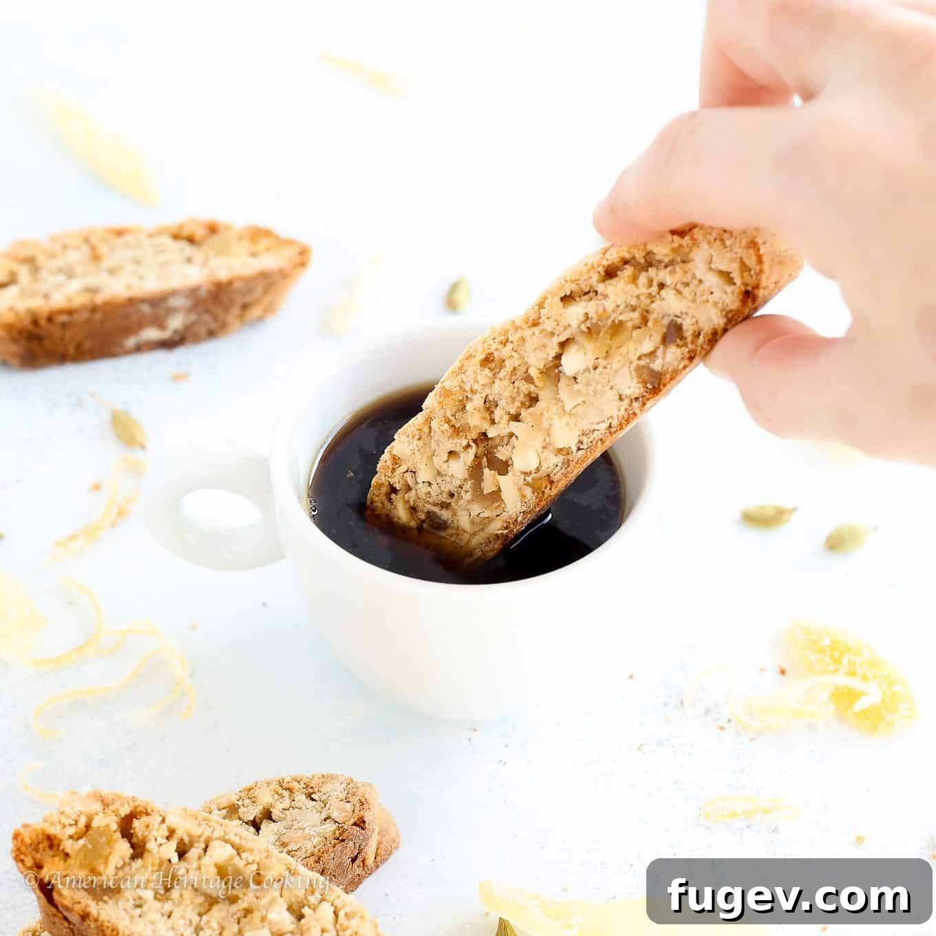 Zesty Ginger-Orange Almond Biscotti 6 Two Ginger Orange Almond Biscotti resting on the rim of a coffee cup
