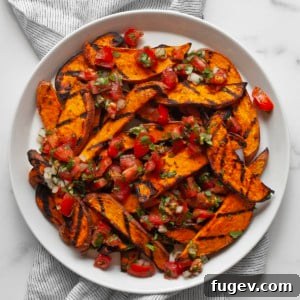 Sweet potatoes topped with pico de gallo on a plate, showcasing the vibrant colors and appealing presentation of the dish.