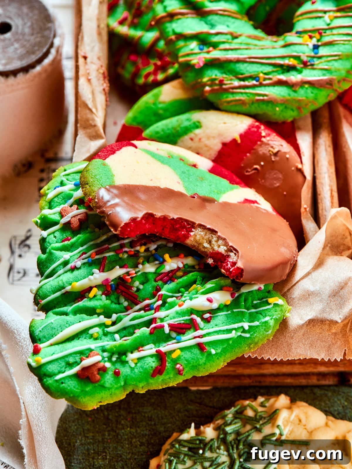 Easy Spritz Cookie Perfection 2 Chocolate-dipped spritz cookie with bright sprinkles and a small bite showing its tender interior.