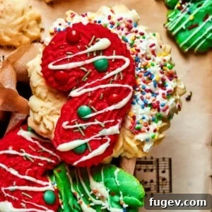 Candy cane-shaped spritz cookie decorated with tiny colorful candy dots for a festive finish.