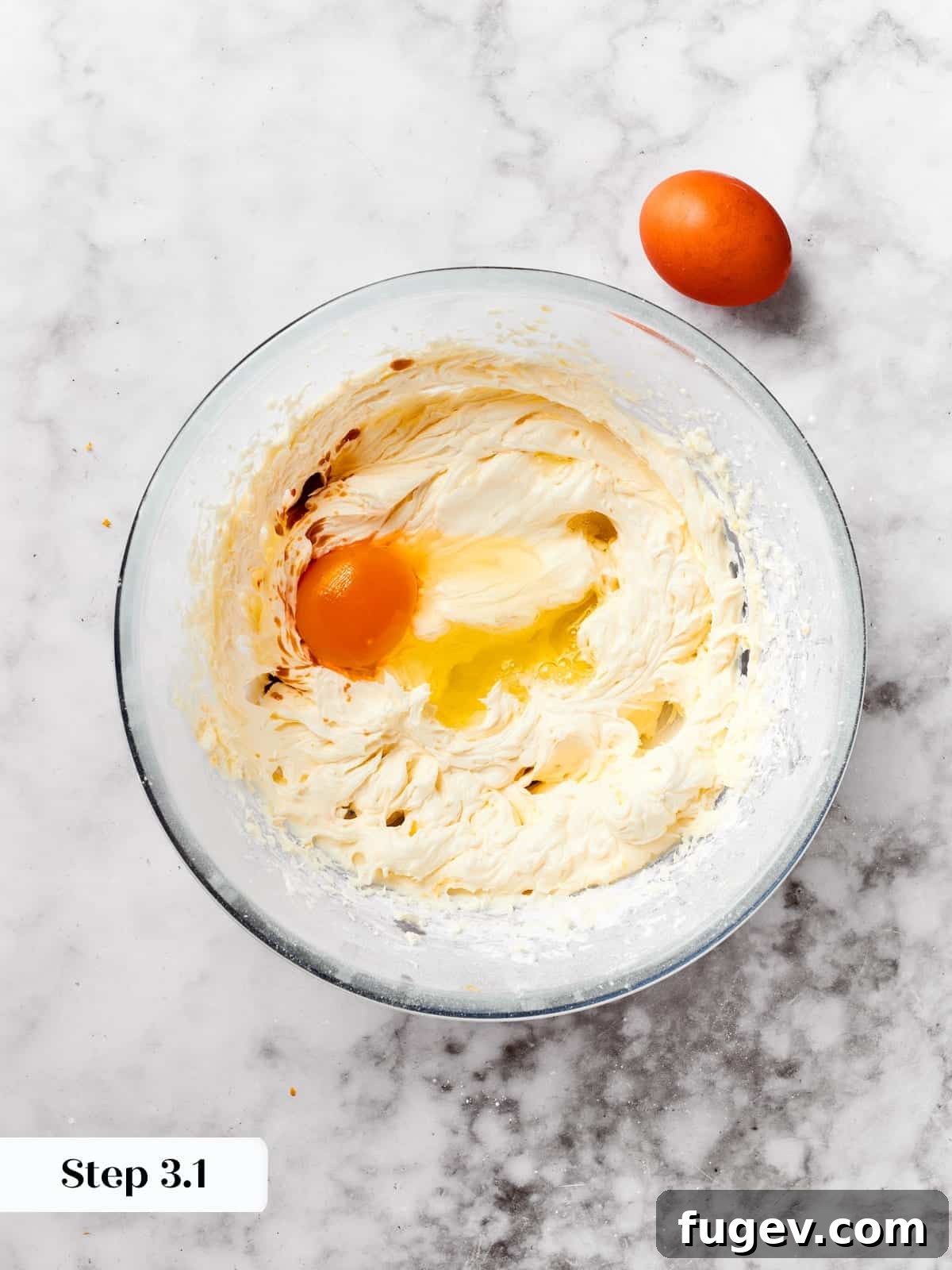 Easy Spritz Cookie Perfection 7 Mixing bowl with eggs and vanilla being whisked together for buttery spritz cookie dough.