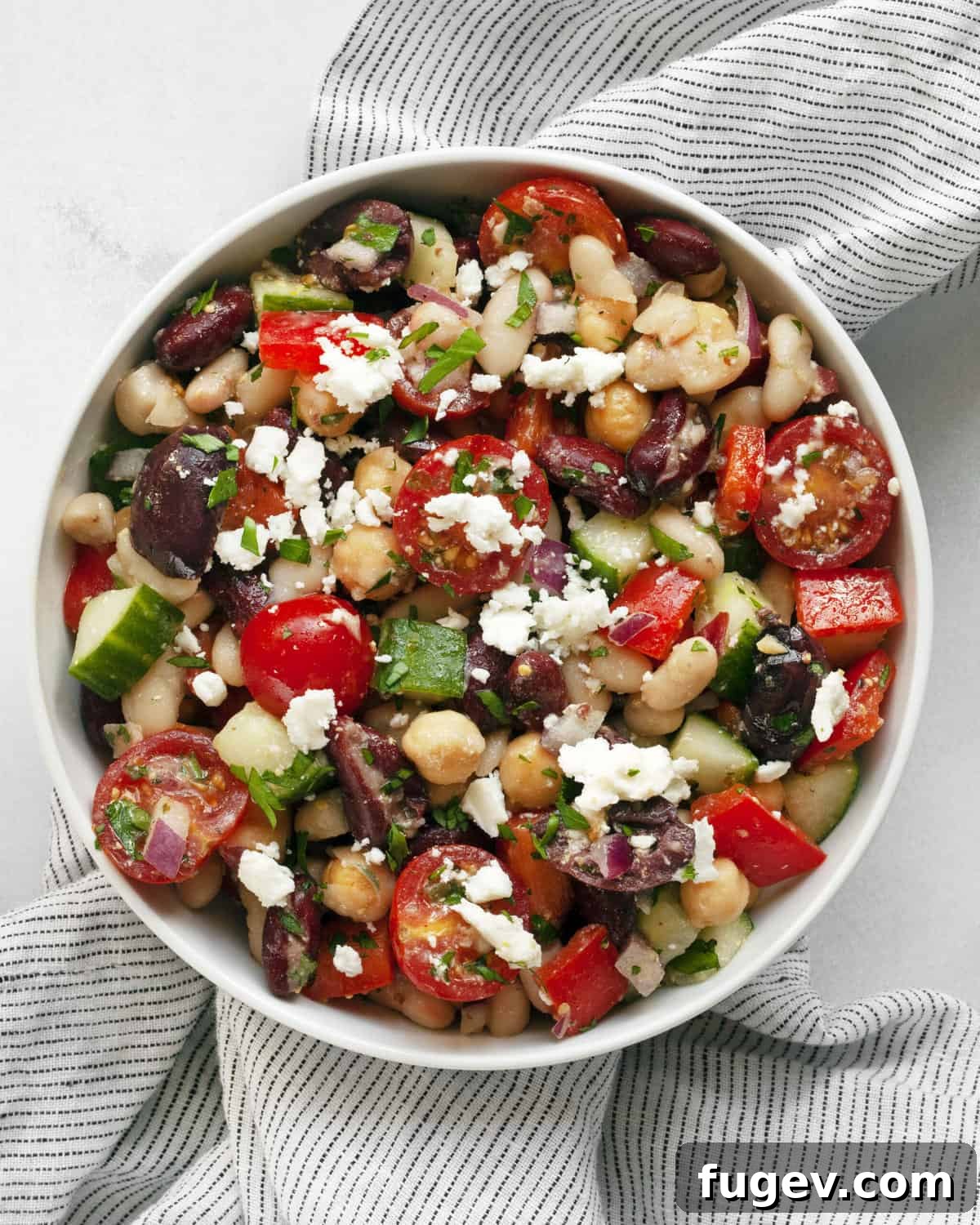 Vibrant Mediterranean Bean Medley 2 Vibrant Mediterranean bean salad served in an elegant white bowl, garnished with fresh herbs.