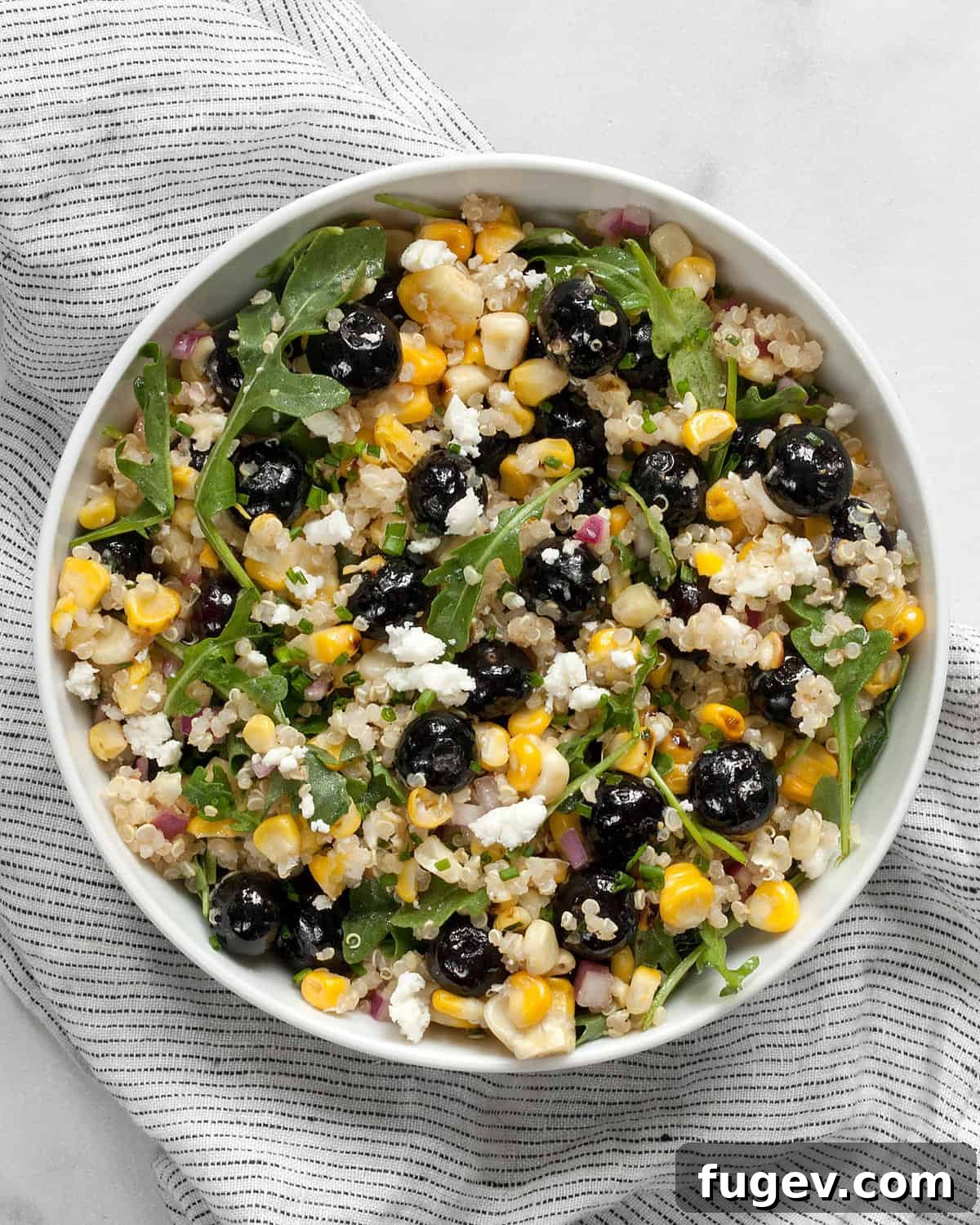Golden Corn Blueberry Medley 2 A beautifully presented blueberry corn salad with quinoa in a rustic bowl, garnished with fresh herbs.