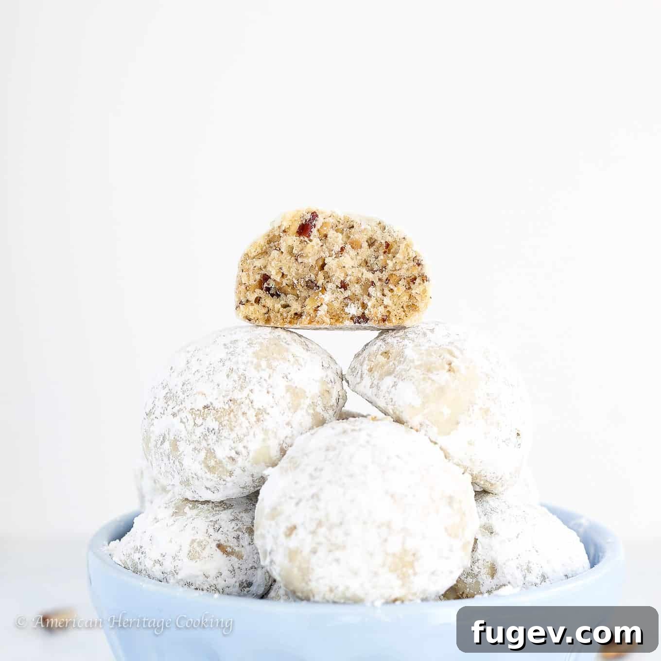 Fiesta Snowball Cookies 4 A Mexican wedding cookie broken in half, showing its crumbly, pecan-filled interior.