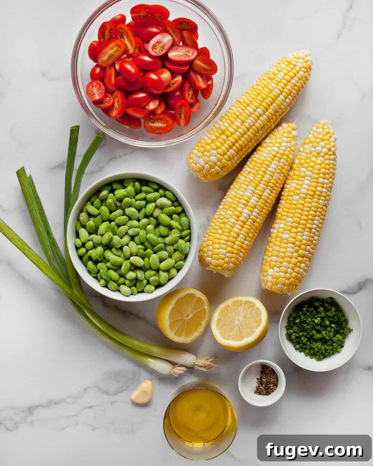 Sunshine Succotash with Edamame and Corn 4 A colorful flat lay of all fresh ingredients including corn cobs, shelled edamame, cherry tomatoes, scallions, a lemon, and fresh chives.