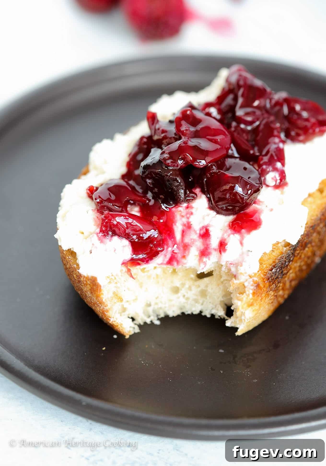 Simply Divine Cherry Jam 4 A close-up shot of cherry preserves on black pepper honey ricotta toast, showing the texture and colors of the ingredients. An easy snack or breakfast, perfect for enjoying summer's bounty year-round.