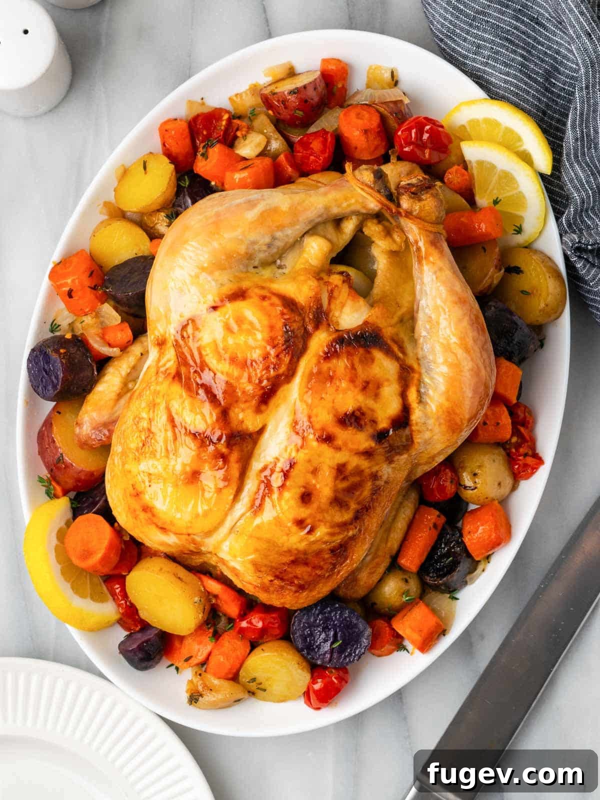 Zesty Lemon Roasted Chicken 3 cooked chicken with vegetables on serving platter.