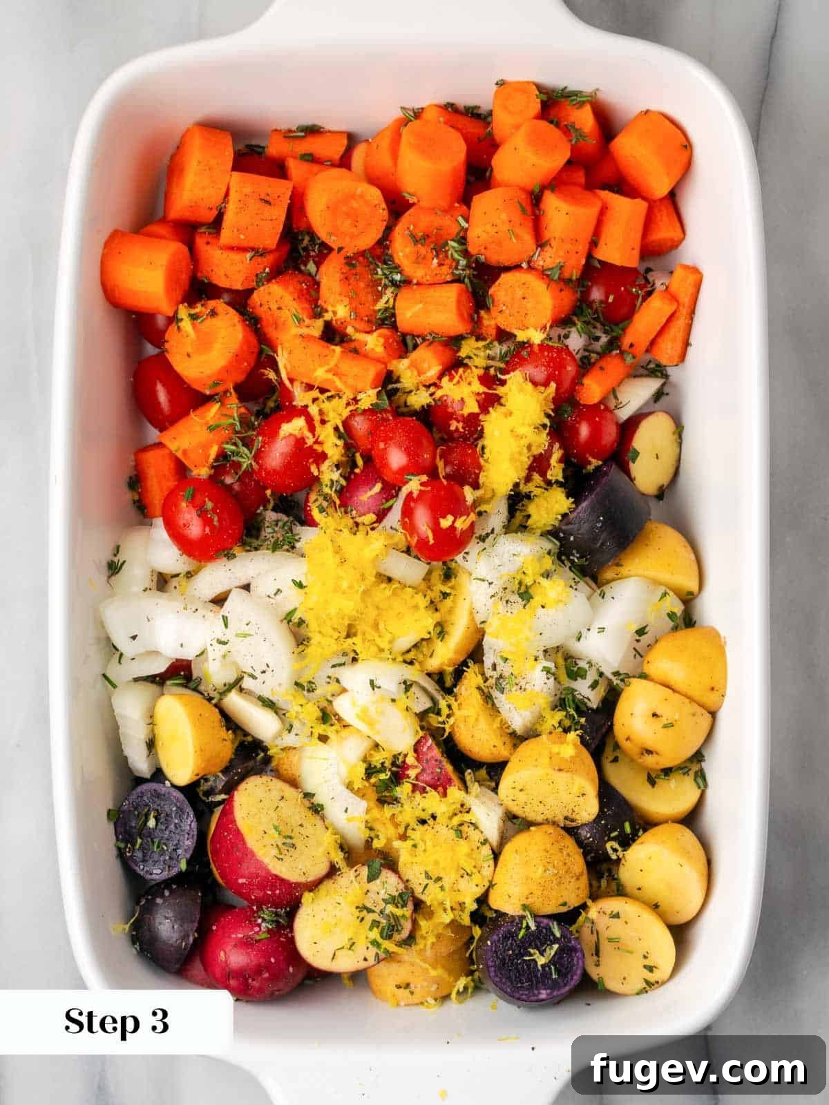 Zesty Lemon Roasted Chicken 5 vegetables sliced in white baking dish.