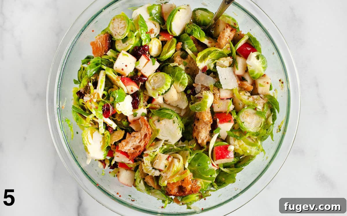 Shaved Brussels Sprout Salad with Crisp Apples and Toasted Walnuts 6 A close-up shot of the finished Brussels sprout and apple salad, with crunchy sourdough croutons perfectly stirred in, showcasing the vibrant textures and colors before serving.