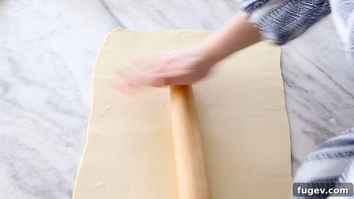 Butter-Wrapped Puff Pastry 3 Inverse Puff Pastry sheet being rolled with a wooden rolling pin