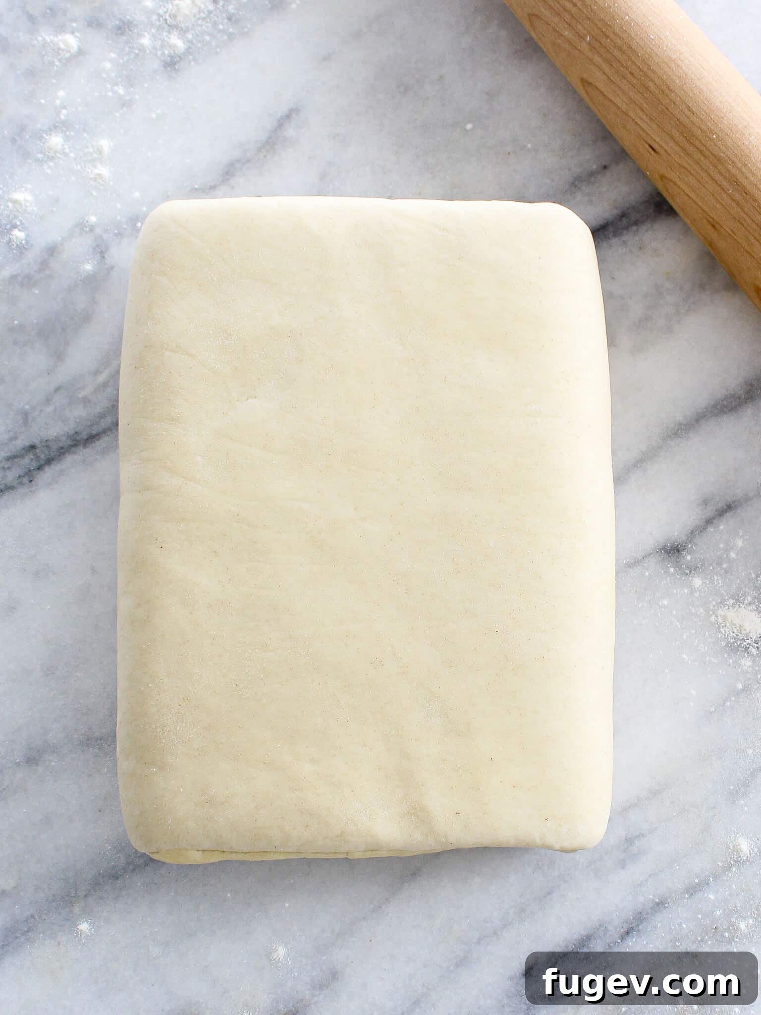 Butter-Wrapped Puff Pastry 5 Inverse Puff Pastry wooden rolling pin on a floured surface