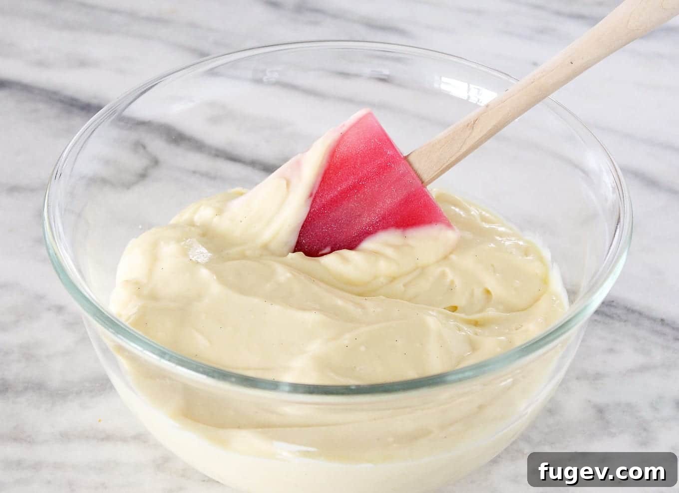 Perfect Homemade Pastry Cream 4 Silky smooth vanilla bean pastry cream, scooped into a bowl with a red silicone spatula.