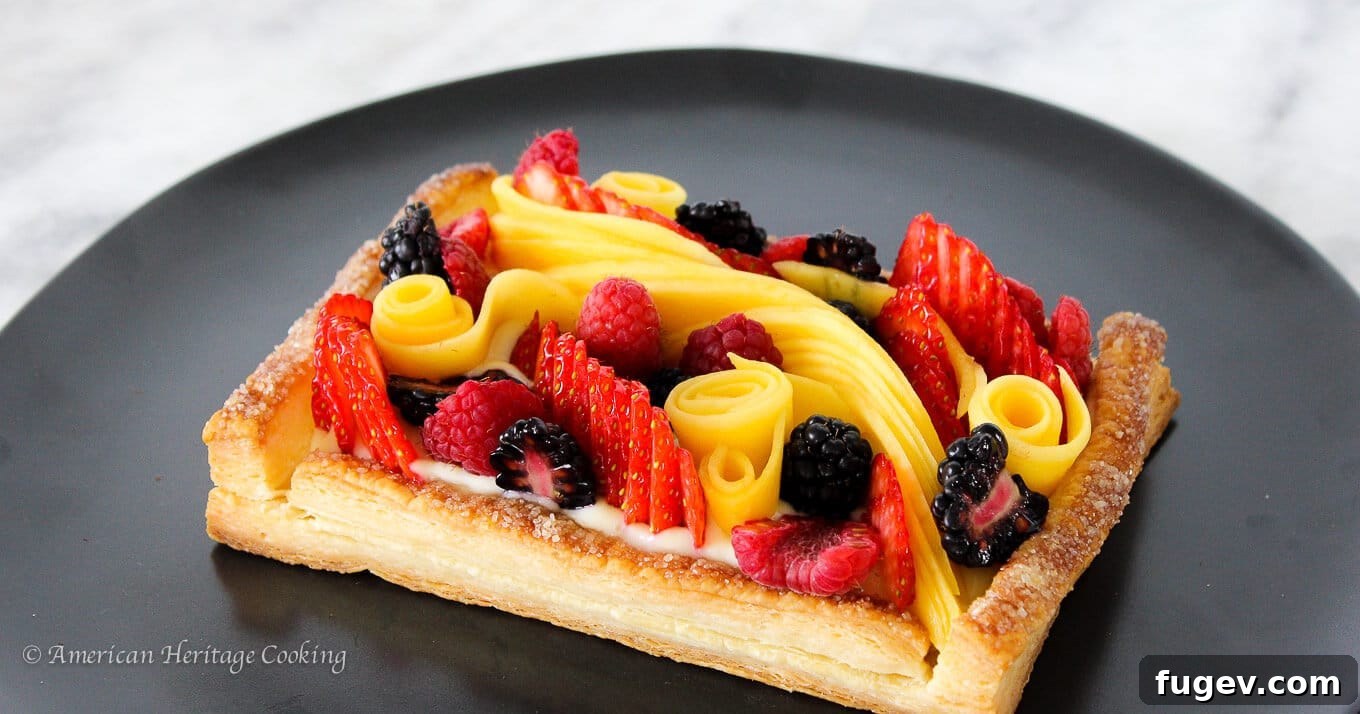 Flaky Fruit Delight 3 Close-up of a puff pastry tart revealing its golden, flaky layers beneath a topping of vibrant fresh fruits.