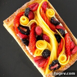 A stunning Puff Pastry Fruit Tart, beautifully adorned with fresh berries and mango slices.
