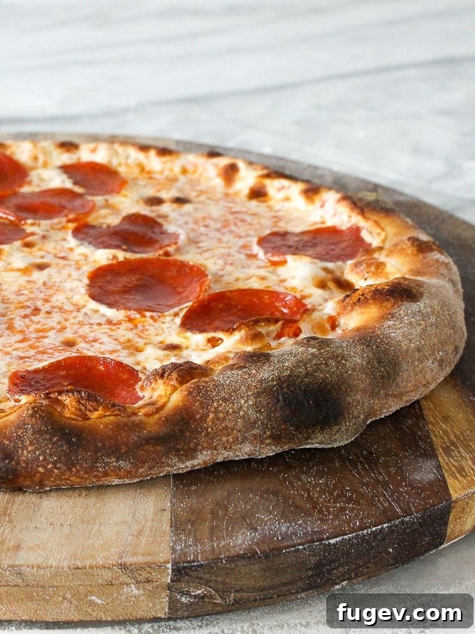 Artisan Sourdough Pizza Dough 5 Finished sourdough pizza served on a rustic wooden board, showcasing its perfectly baked crust and delicious toppings.