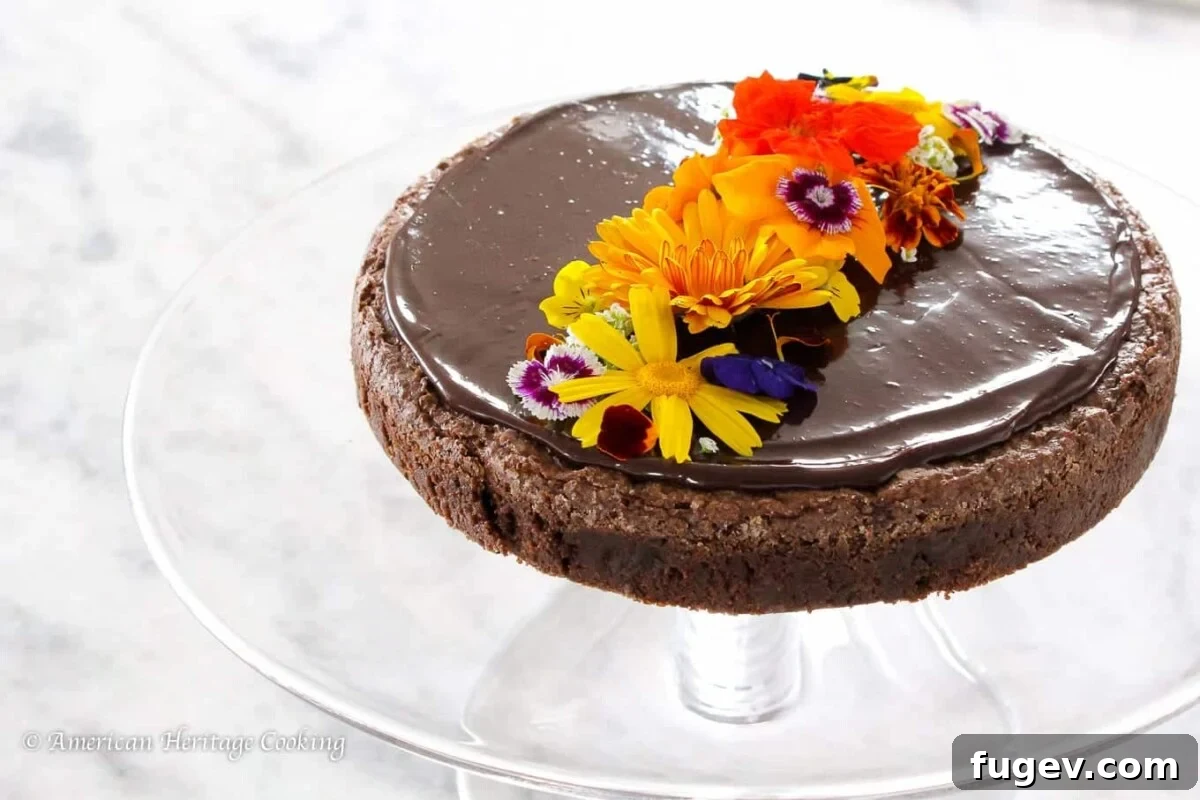 Decadent Flourless Chocolate Torte 3 Flourless chocolate torte with edible flours arranged on top.