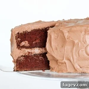 Chocolate Mayonnaise Cake on a cake stand, with a slice removed to show moist layers.