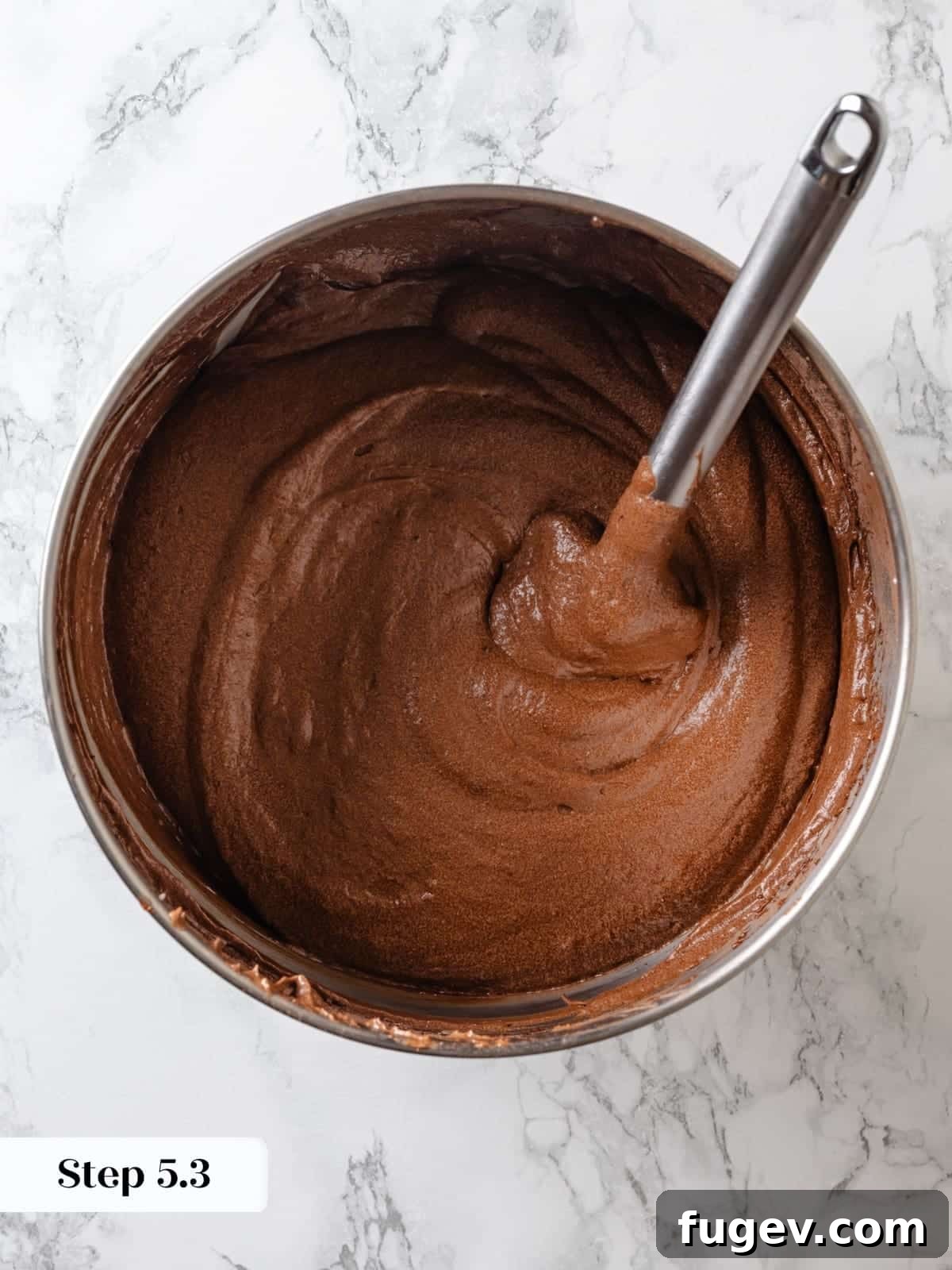 Sinfully Rich Chocolate Delight 12 The final stage of folding the Devil’s food cake batter with a rubber spatula, ensuring all ingredients are gently and fully combined.