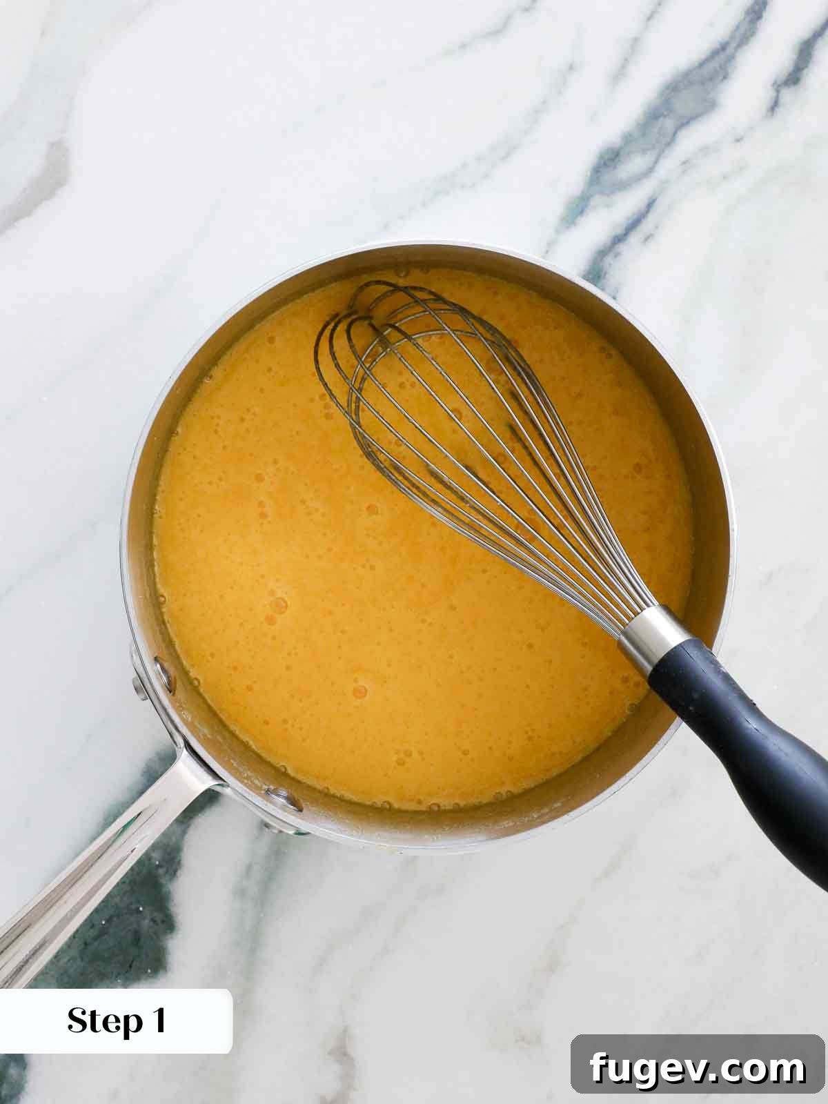 Bright & Tangy Lemon Curd 6 Close-up of a bowl containing whisked whole eggs and egg yolks, appearing smooth and uniform, ready for the next step in making lemon curd.