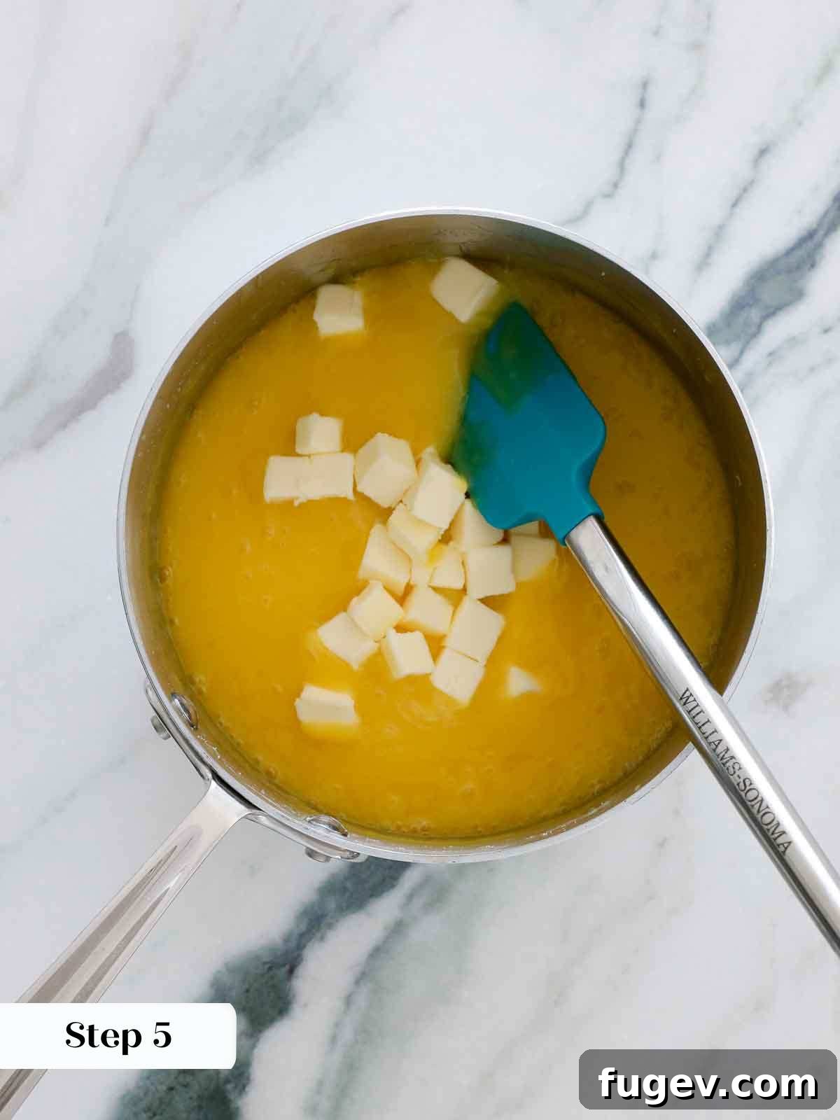 Bright & Tangy Lemon Curd 10 Cubed unsalted butter being added to the hot lemon curd in a saucepan, just after being removed from the heat.