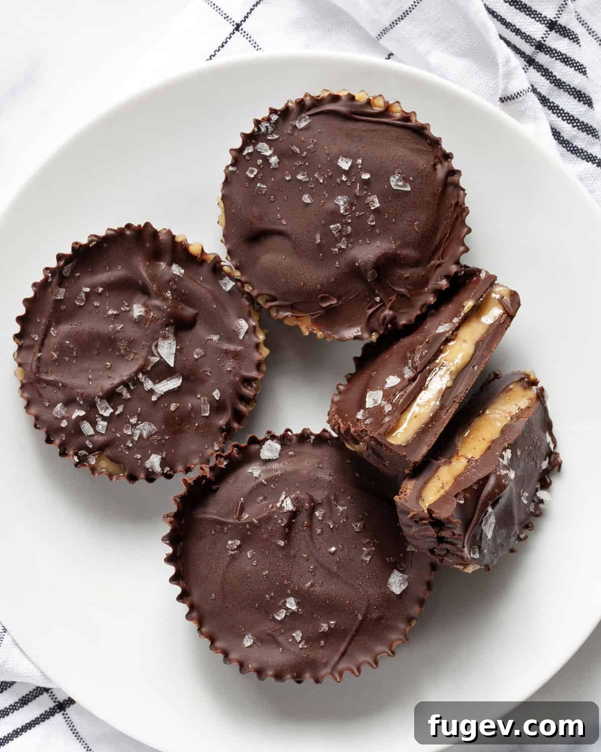 DIY Peanut Butter Delights 2 Three whole peanut butter cups and one split in half, showcasing the rich chocolate shell and creamy peanut butter filling.