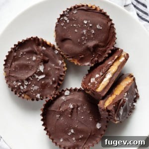 Three whole peanut butter cups and one split in half, highlighting the filling.