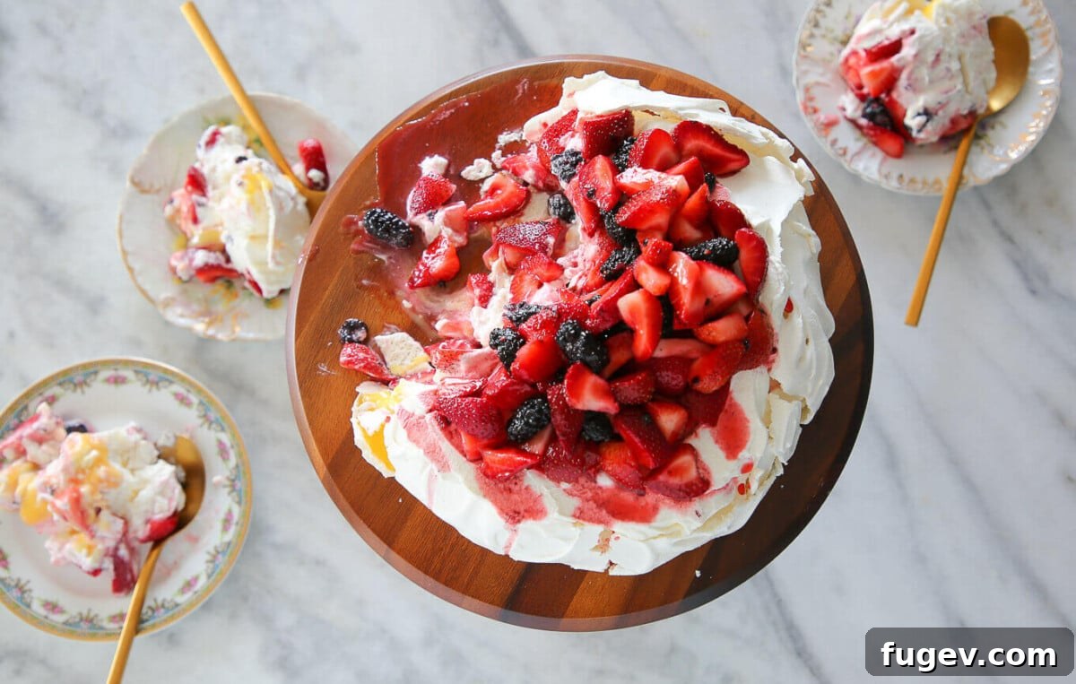 Zesty Berry Pavlova Dream 4 A delectable slice of Lemon Berry Pavlova Cake, featuring layers of crisp meringue, creamy topping, and a vibrant cascade of fresh berries, presented beautifully.