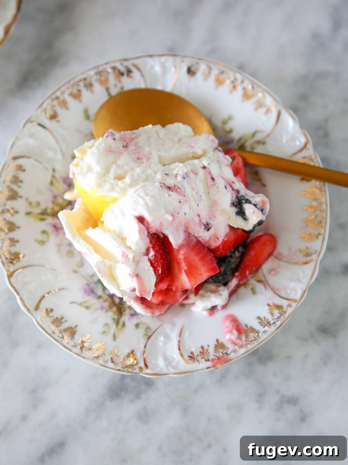 Zesty Berry Pavlova Dream 6 An exquisitely plated individual serving of Lemon Berry Pavlova Cake, showcasing its beautiful layers of meringue, whipped cream, bright lemon curd, and a vibrant scattering of fresh berries on a white dish.