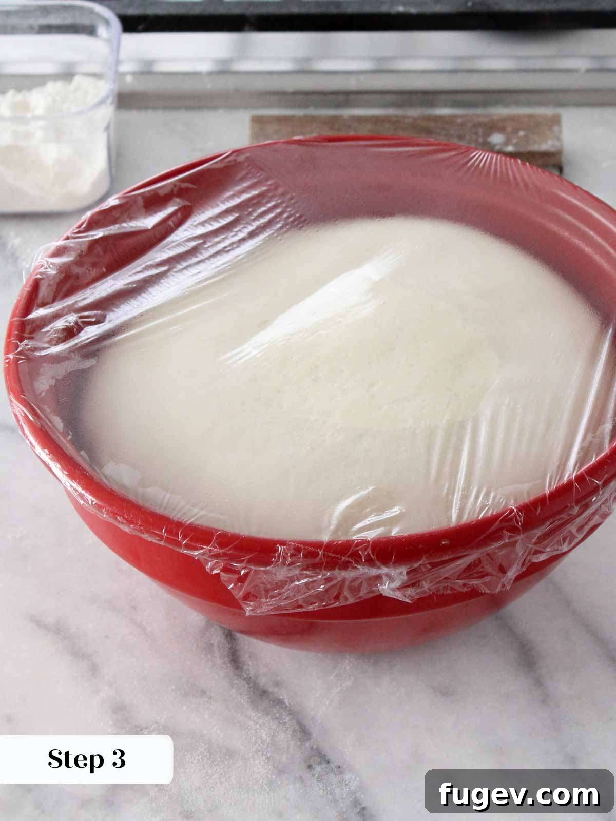 Perfect Fluffy Brioche Buns 4 Proofed brioche dough resting in a red bowl, visibly doubled in size and ready for shaping.