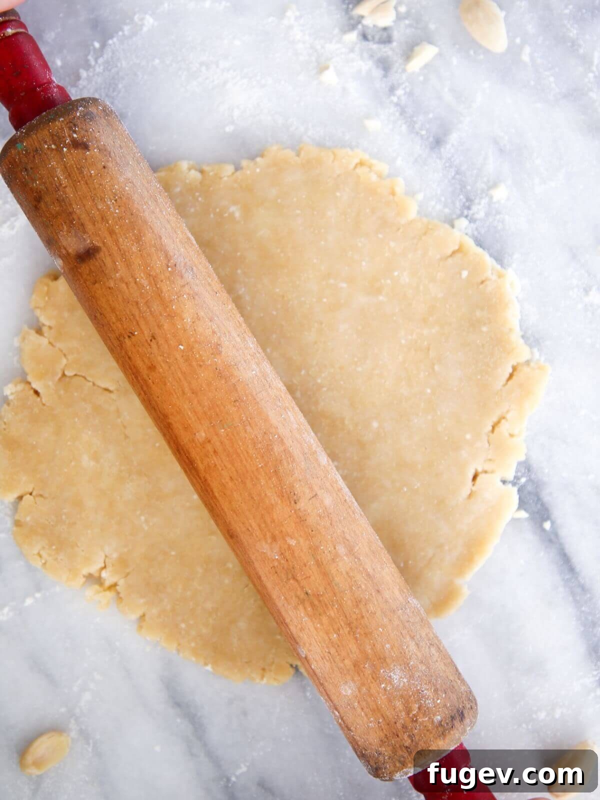 Nutty Almond Flour Pie Crust 2 Almond pie crust rolled out on white marble, ready for baking.