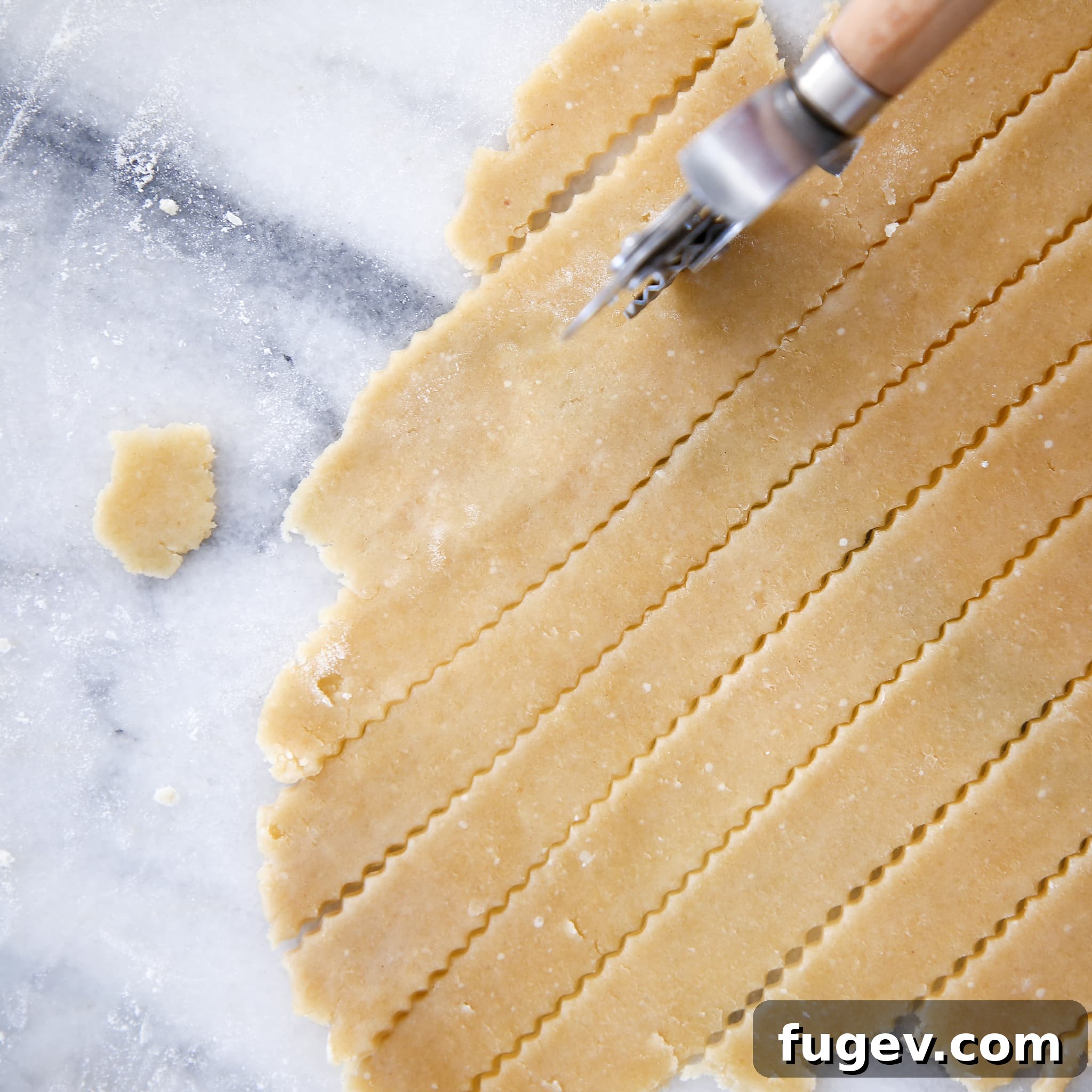 Nutty Almond Flour Pie Crust 3 A fluted cutting wheel cutting strips of an almond flour pie crust, perfect for lattice work.