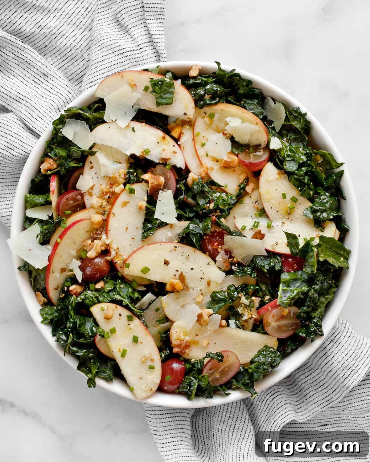 Crisp Apple Kale Salad 2 A vibrant bowl of Kale Apple Salad, showcasing crisp greens, sliced apples, and grapes.
