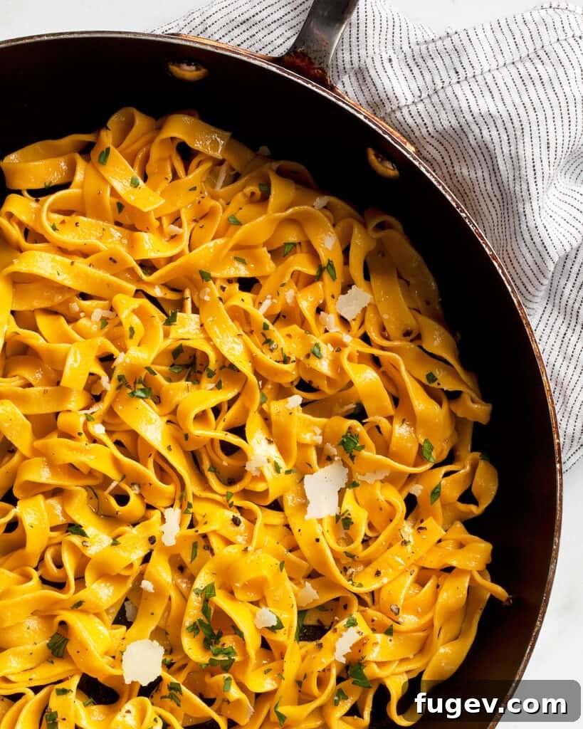 Vibrant Carrot Pasta 7 A bowl of freshly cooked carrot pasta, garnished with green herbs, ready to be enjoyed.