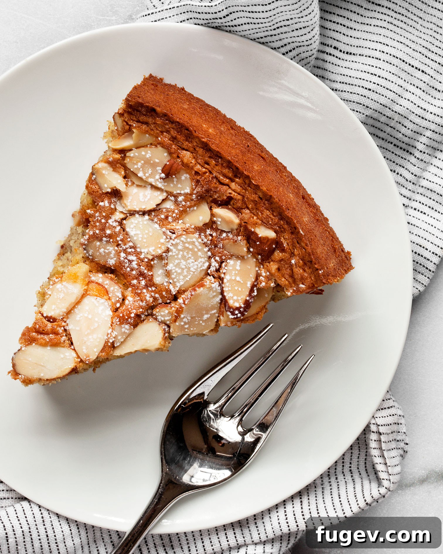 Golden Almond Flour Delight 2 A perfectly baked slice of golden brown almond cake with a fork resting on a plate, showcasing its moist texture.
