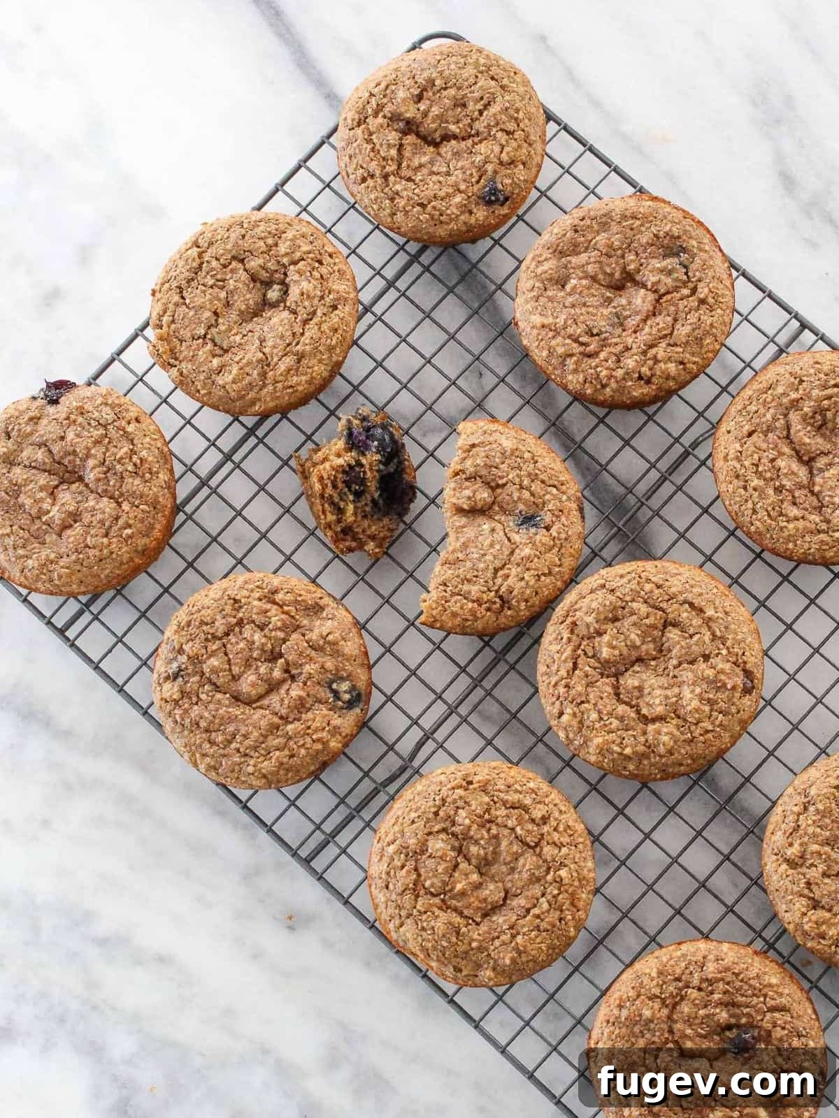 Power-Packed Banana Muffins 13 Freshly baked banana protein muffins cooling on a rack, set against a white marble backdrop, perfect for healthy meal prep.