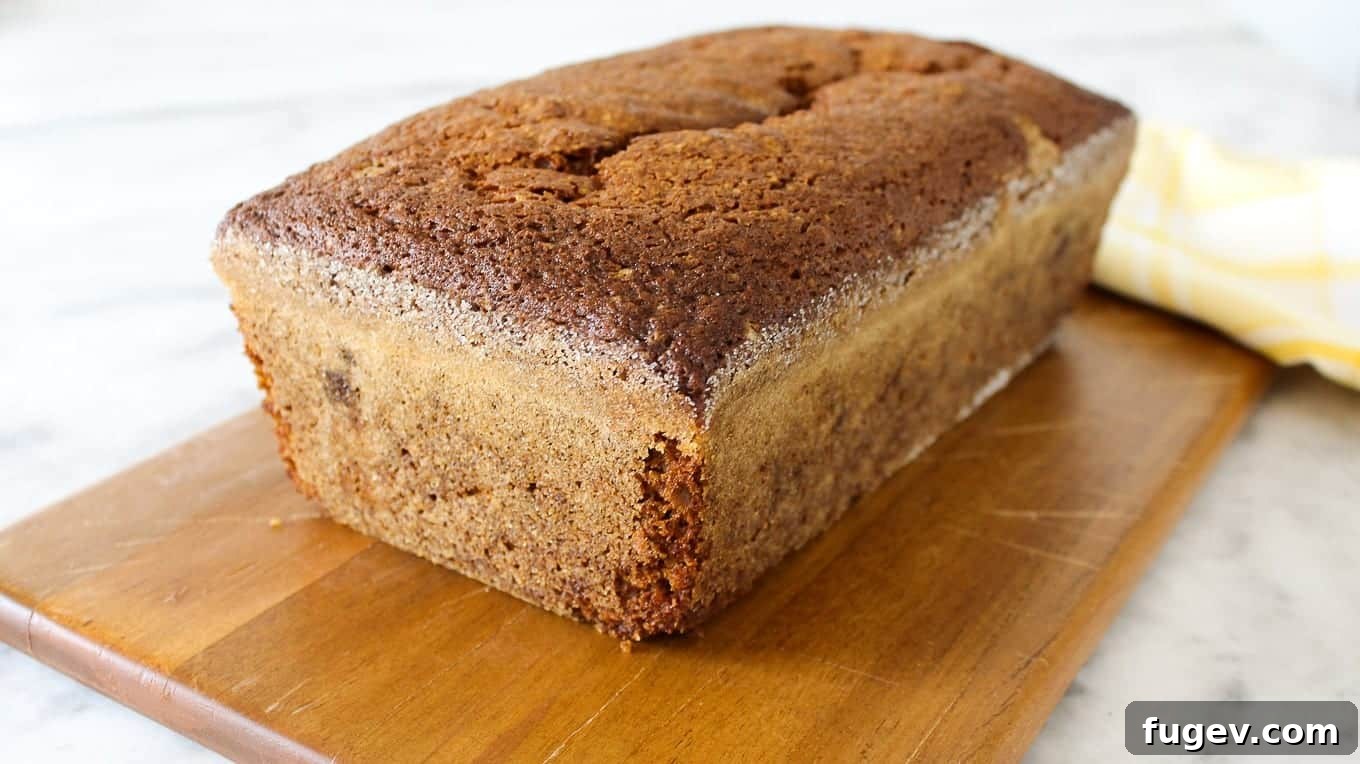 Spiced Pumpkin Delight 3 A perfectly baked, unsliced loaf of pumpkin bread resting on a rustic wooden board, ready to be enjoyed.