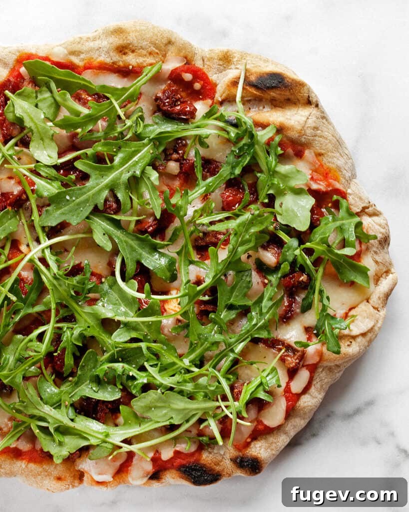 Charred Arugula and Sun-Kissed Tomato Pizza 7 Full view of the Grilled Sun-Dried Tomato and Arugula Pizza, freshly topped and ready to serve.
