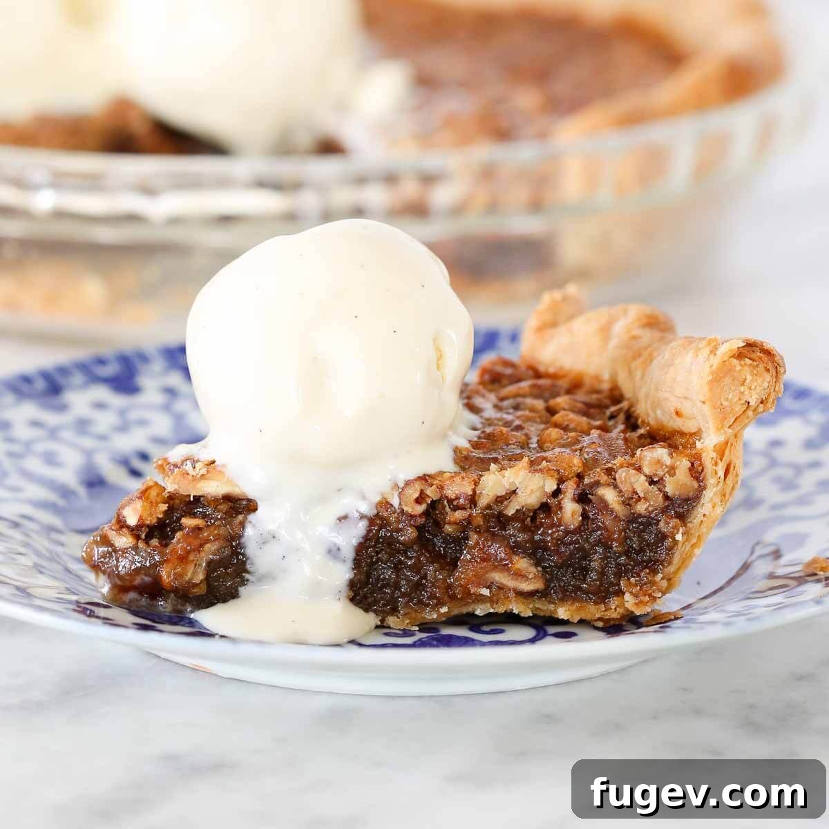 Whiskey-Kissed Pecan Dream 3 A delectable slice of Bourbon Pecan Pie, featuring a glistening filling and whole pecans, served with a scoop of creamy vanilla ice cream.