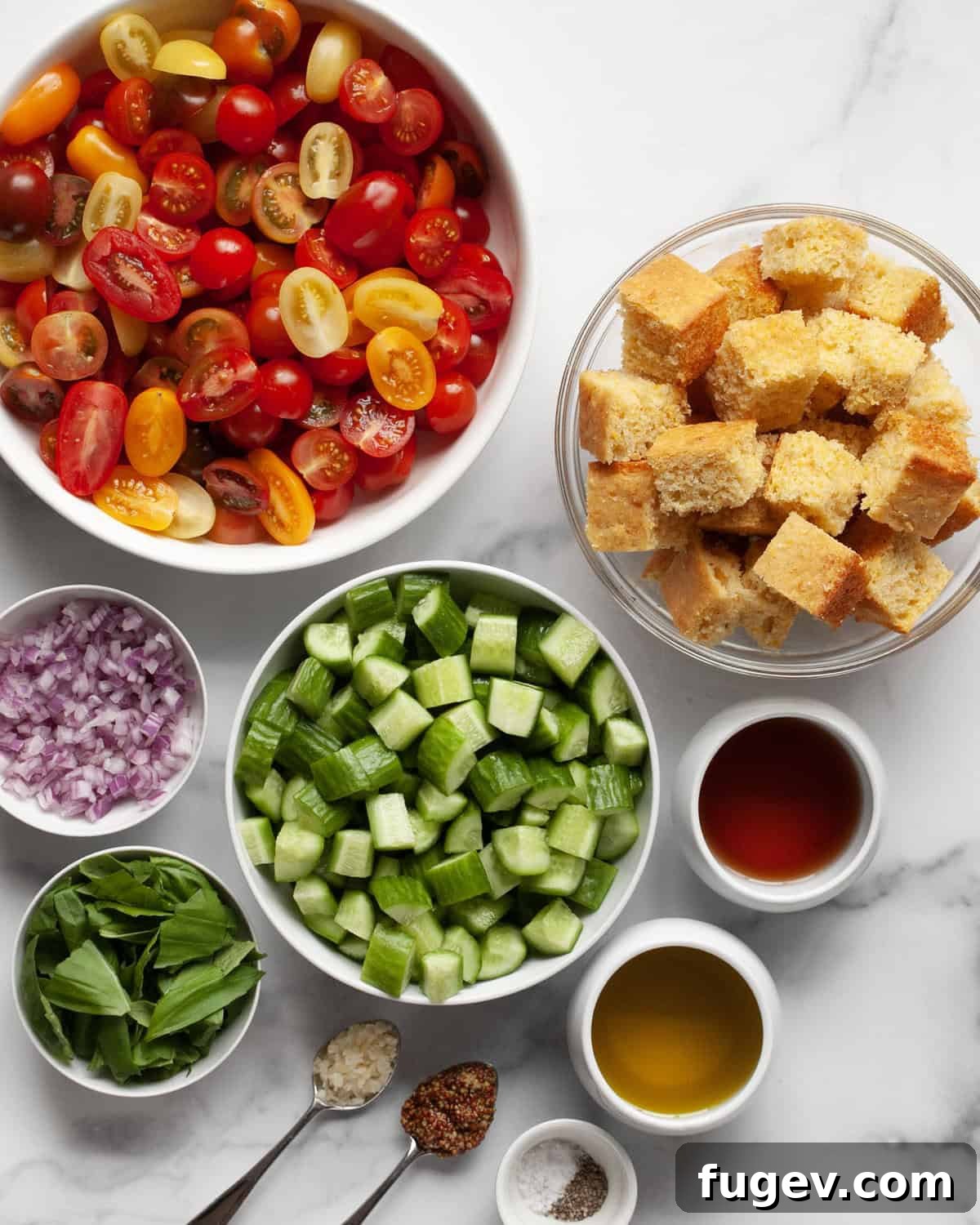 Rustic Cornbread Panzanella 3 A colorful spread of ingredients for Cornbread Panzanella Salad, including cornbread cubes, various fresh vegetables, and dressing components.