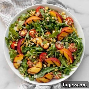 Grilled peach salad with corn on a plate.
