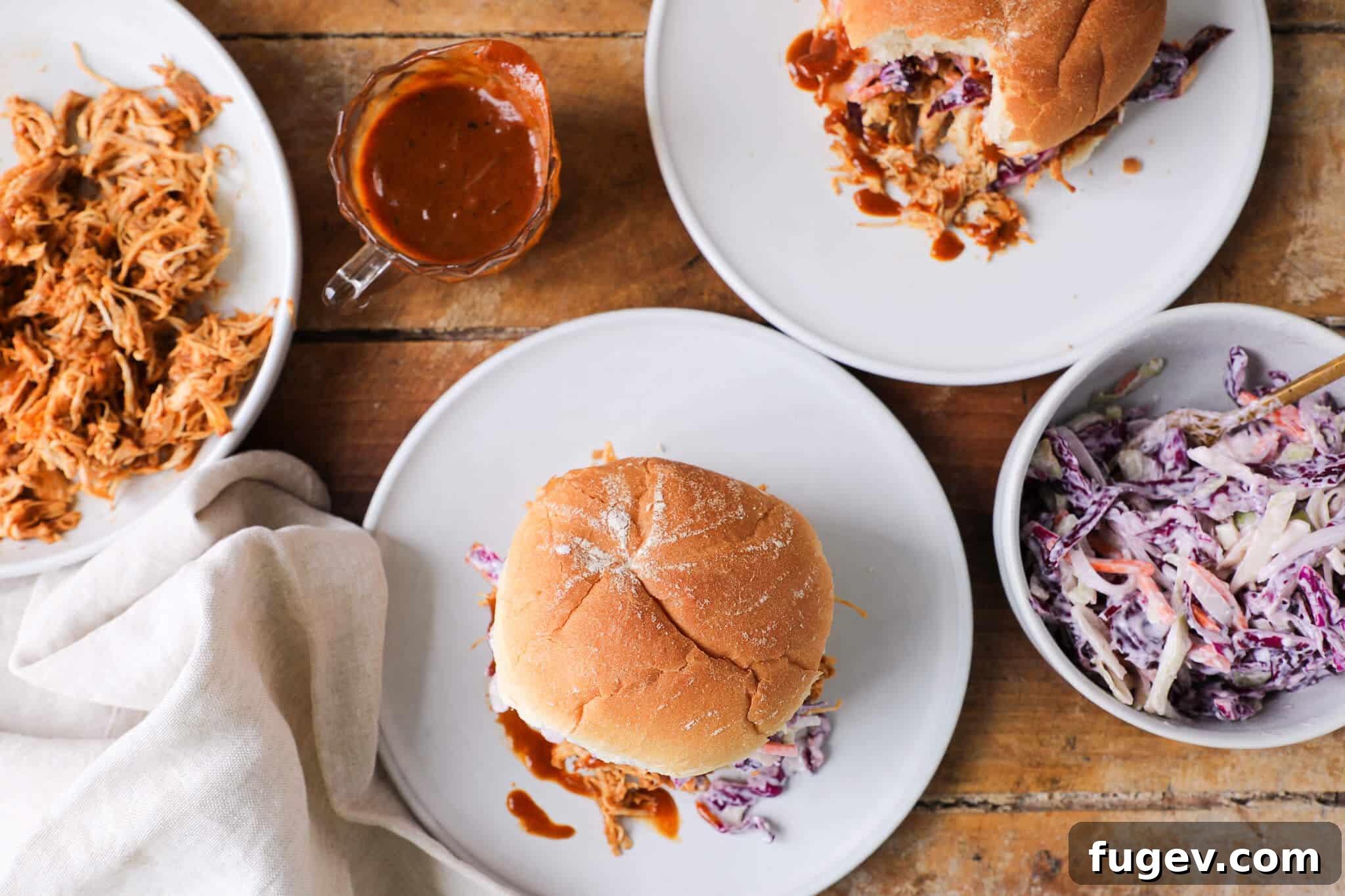 Fall-Apart Slow Cooker BBQ Pulled Chicken Sandwiches 3 Delicious slow cooker barbecue pulled chicken sandwich on a rustic tablescape