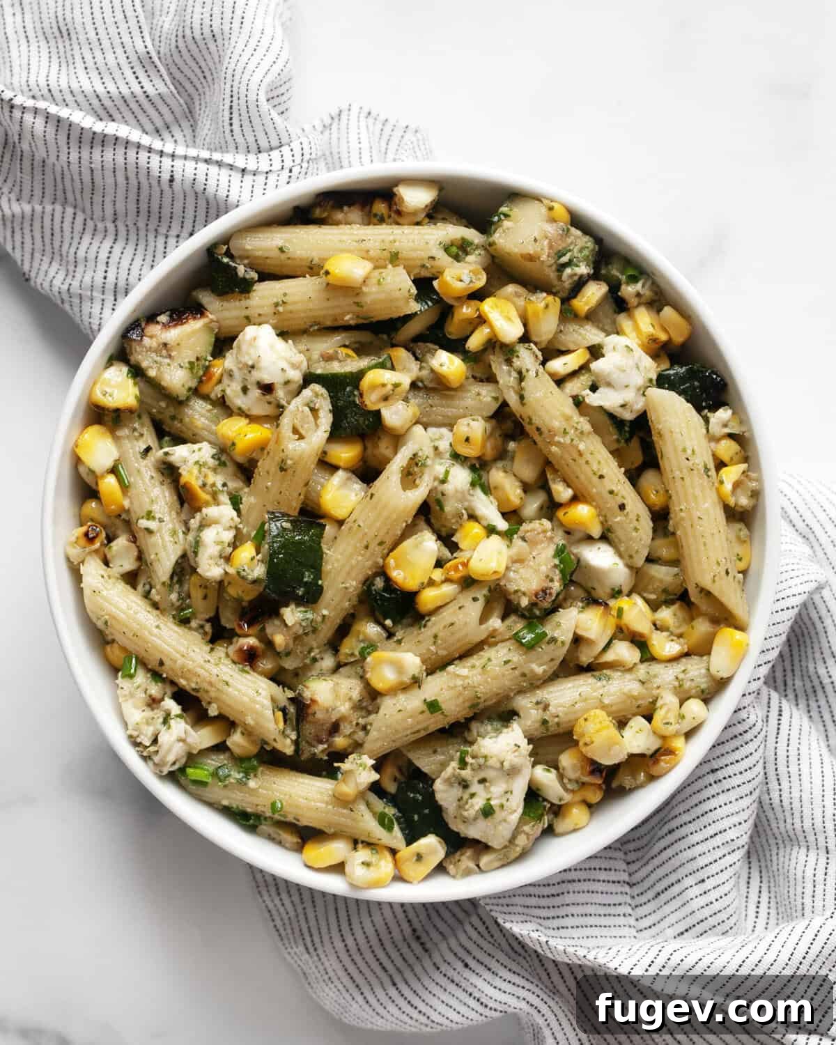Vibrant Summer Pasta with Grilled Zucchini, Sweet Corn, and Mint Pesto 3 A generous serving of grilled zucchini corn pasta with mint pesto, artfully arranged in a rustic bowl, highlighting its freshness and vibrant colors.