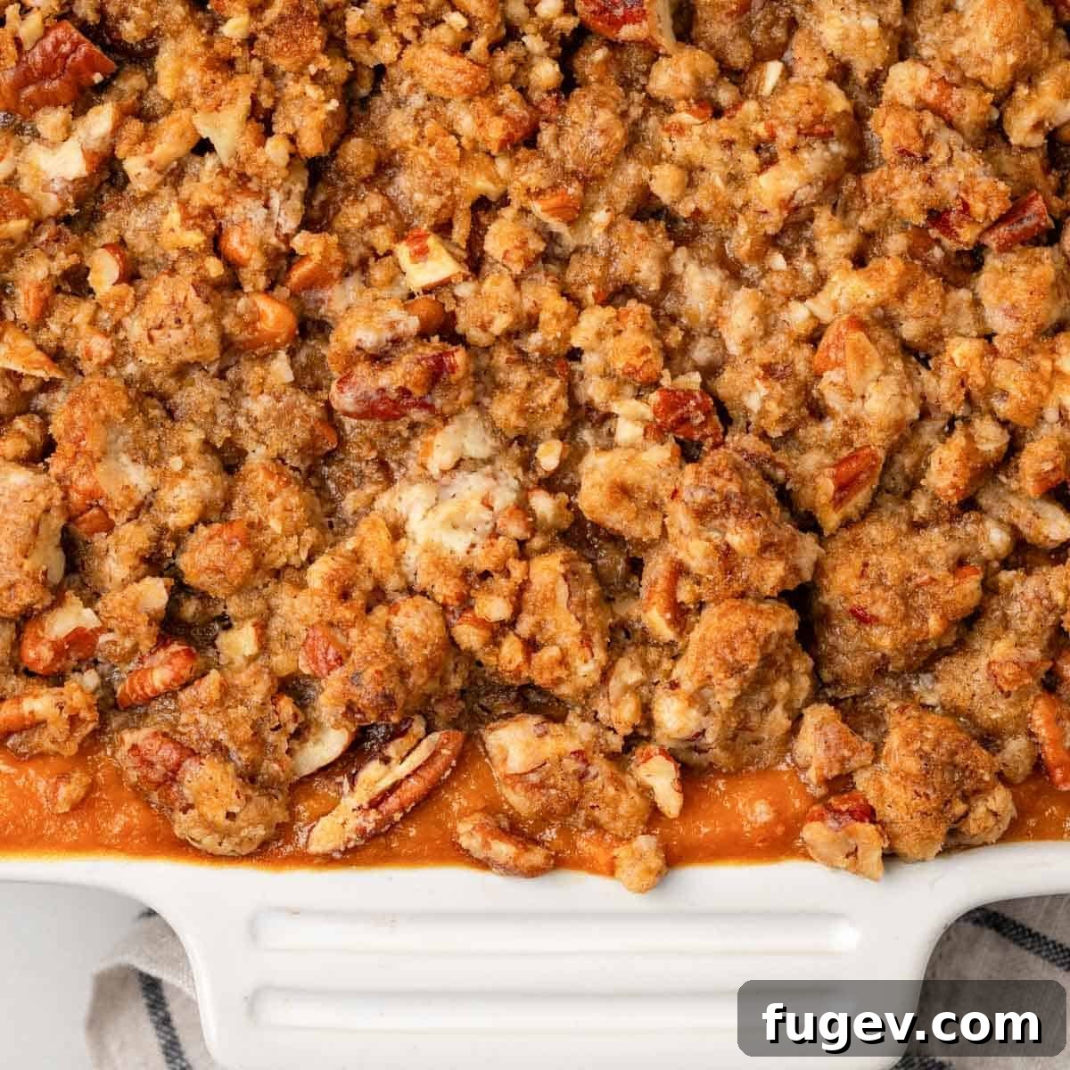 Golden Pecan Sweet Potato Bake 4 A beautifully baked sweet potato casserole with a golden-brown pecan topping in a white serving dish, ready for the table.